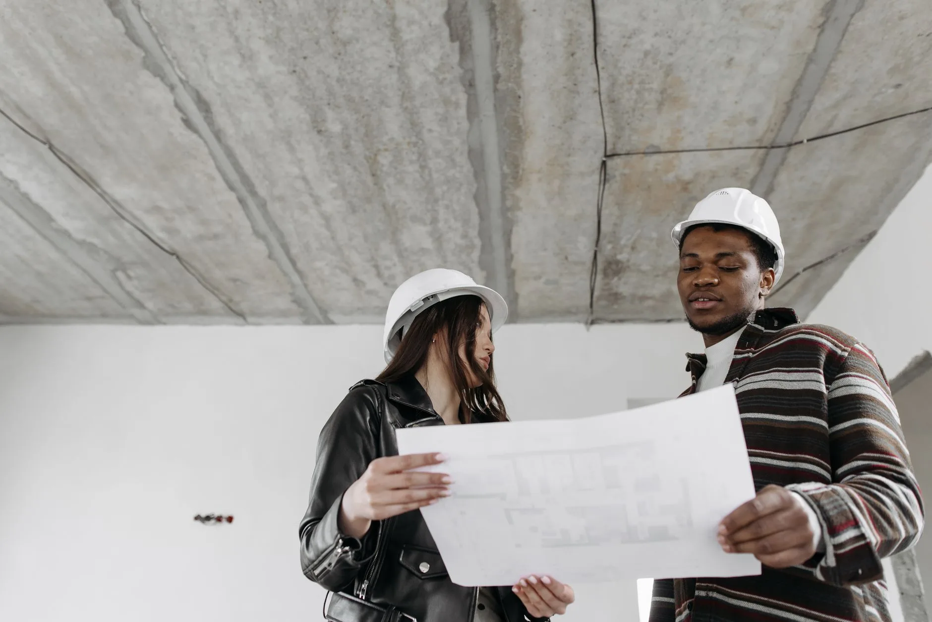 Équipe de chantier consultant un plan dans un bâtiment en travaux