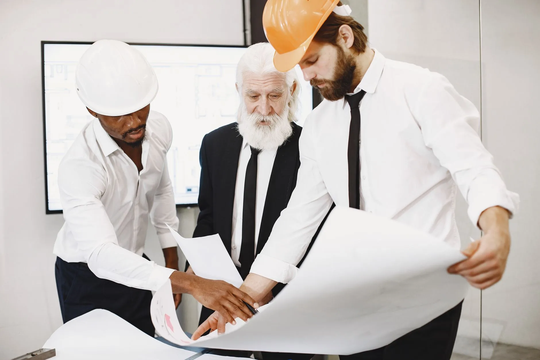 Équipe d’architectes examinant des plans en agence